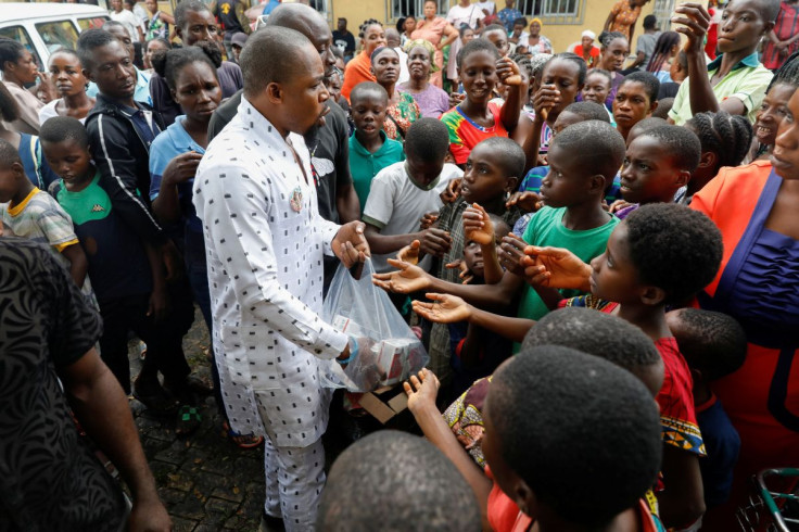 People crowd to receive free grocery items being distributed outside a relief camp in Obite community, after they fled their homes following a massive flood in Rivers state